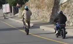Akrobasi hareketleri yaparak  motosiklet kullanan şahıs kamerada