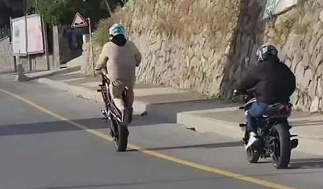Akrobasi hareketleri yaparak  motosiklet kullanan şahıs kamerada